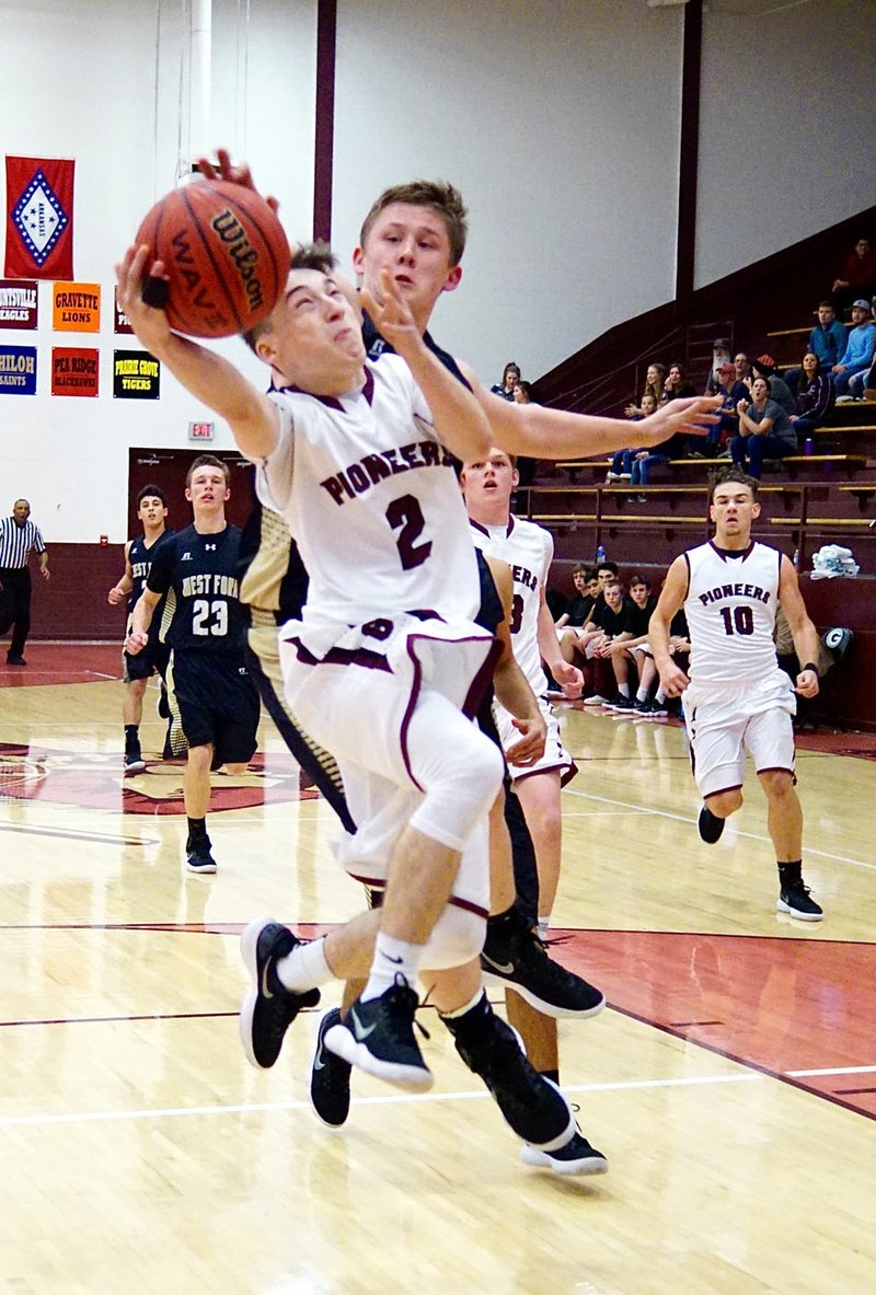 Westside Eagle Observer/RANDY MOLL Gentry's Ethan Hammond, a senior, attempts a layup under the basket but is fouled by a West Fork defender during play between the two teams in Gentry on Friday night.