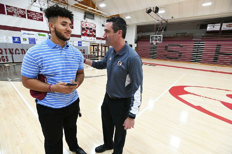 NWA Democrat-Gazette/J.T. WAMPLER Zak Clark, head football coach at Springdale High School (RIGHT) visits with defensive lineman Isaiah Nichols before Nichols signed a national letter of intent with the University of Arkansas Wednesday Dec. 20, 2017.