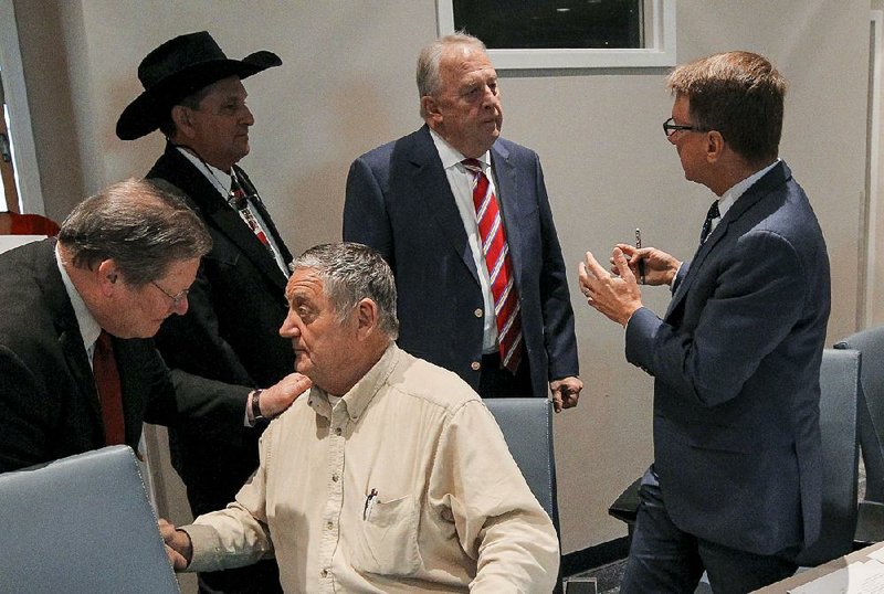 Metroplan board members (from left) Little Rock Mayor Mark Stodola, Lonoke County Judge Doug Erwin (in hat), Faulkner County Judge Jim Baker (seated), North Little Rock Mayor Joe Smith and Metroplan Executive Director Tab Townsell discuss the board’s Wednesday vote on the Interstate 30 project.