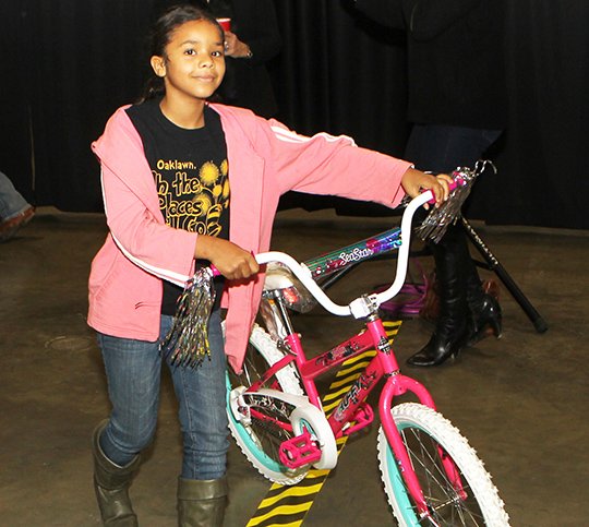 The Sentinel-Record/Richard Rasmussen WINNER: Jalissa Davis, 10, of Hot Springs, is all smiles after winning a bicycle at the 32nd annual Christmas for Kids event at the Hot Springs Convention Center on Thursday.