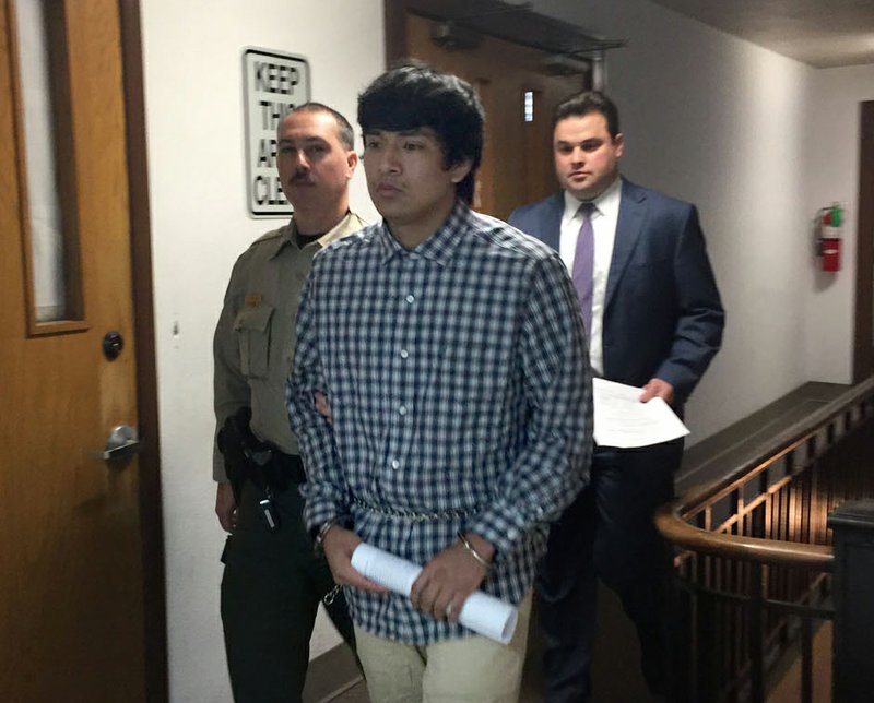 NWA DEMOCRAT-GAZETTE/TRACY M. NEAL Edward Alexis Martinez-Torres, 22, of Springdale pleaded guilty Thursday to first degree murder in connection with the death of a 3-month-old boy. Martinez-Torres was sentenced to 25 years in prison. He was escorted by a sheriff's deputy from the courtroom. Drew Ledbetter, Martinez-Torres'attorney, is behind the two men.