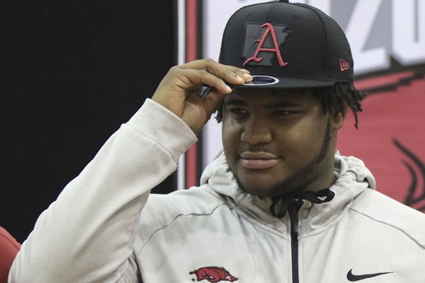 Fordyce defensive lineman Billy Ferrell puts on an Arkansas hat during a signing day ceremony on Wednesday, Dec. 20, 2017, in Fordyce. 