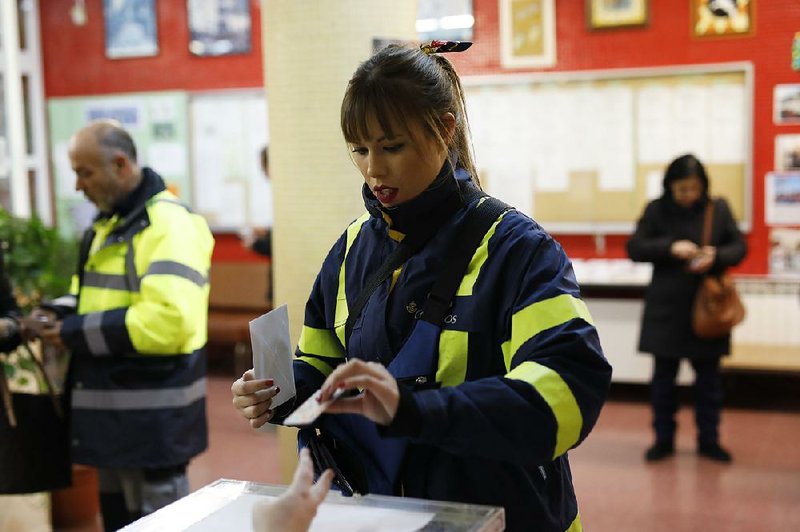 A postal worker casts her vote Thursday in the Catalan regional election at a polling station in Tarragona, Spain.