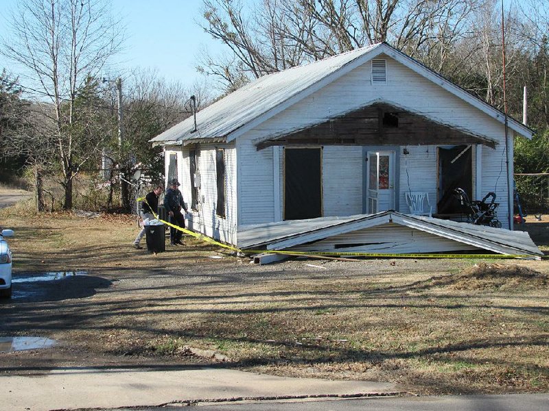 An Arkansas State Police detective and trooper begin investigating the early morning explosion and fire at a home in Paris. The front porch roof collapsed in the explosion.