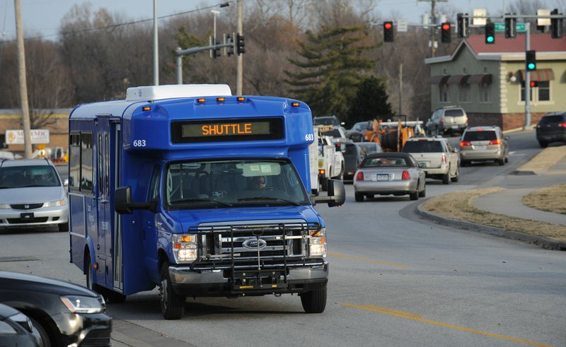 File Photo/NWA Democrat-Gazette/ANDY SHUPE A Ozark Regional Transit shuttle makes its way west on Backus Avenue earlier this year in Springdale. Transit officials, with help from a $140,000 Walton Family Foundation grant, commissioned a study for a bus system on U.S. 71B running at 15-minute intervals to connect the cities and form a spine for regional public transportation, fed by a system of local routes.