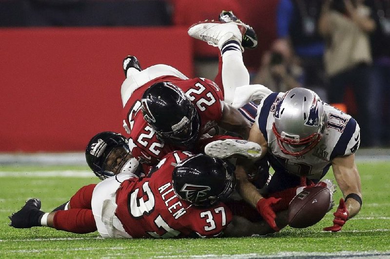 The Patriots’ Julian Edelman (right) makes a catch as the Falcons’ Ricardo Allen and Keanu Neal defend Feb. 5 during Super Bowl 51 in Houston. The play helped rally the Patriots from a 28-3 deficit to a 34-28 victory.