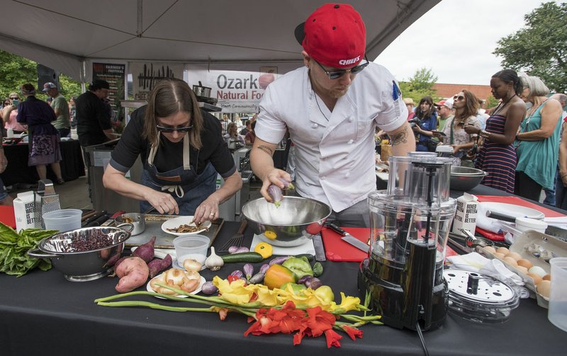 File Photo /J.T. WAMPLER Chef Chrissy Sanderson, left, of Fayetteville's Mockingbird Kitchen and chef Joshua Walters of Bentonville's MOD Restaurant &amp; Social work on their winning entry during the Roots Festival Chef Cookoff 2017. Happening at the Fayetteville Farmers Market, the the "Iron Chef" style competition lets chefs become rock stars as onlookers take in a favorite Roots Festival tradition.