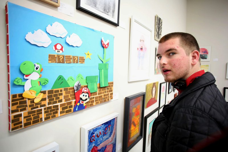 Brandon Baskin, a student at Life Styles Inc., looks Wednesday through the Holiday Art Sale gallery inside the Stensgaard Center in Fayetteville. Artists of the facility created the pieces that include painting, bead jewelry, Christmas ornaments and paper goods for sale with a percentage going to the artist and the art program.
