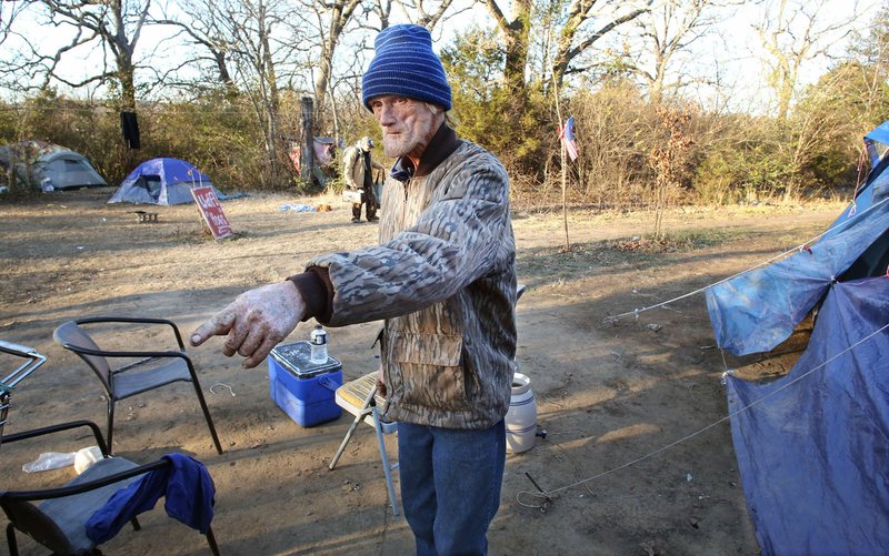 Jerry McCain describes Tuesday, December 12, 2017, his efforts to keep his campground, located near the 7 Hills Homeless Center in Fayetteville, and the immediate surrounding area clean. The center has been in it's South School Avenue location for almost two years and has received upgrades that have included the new sidewalk in the area, a concrete drive and parking lot and a covered bus stop on the grounds. 