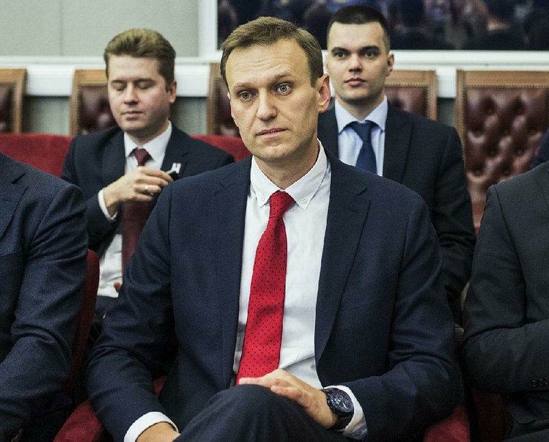 Russian opposition leader Alexei Navalny, who submitted endorsement papers necessary for his registration as a presidential candidate, center, sits at the Russia's Central Election commission in Moscow, Russia, Monday, Dec. 25, 2017. Russian election officials have formally barred Russian opposition leader Alexei Navalny from running for president. 