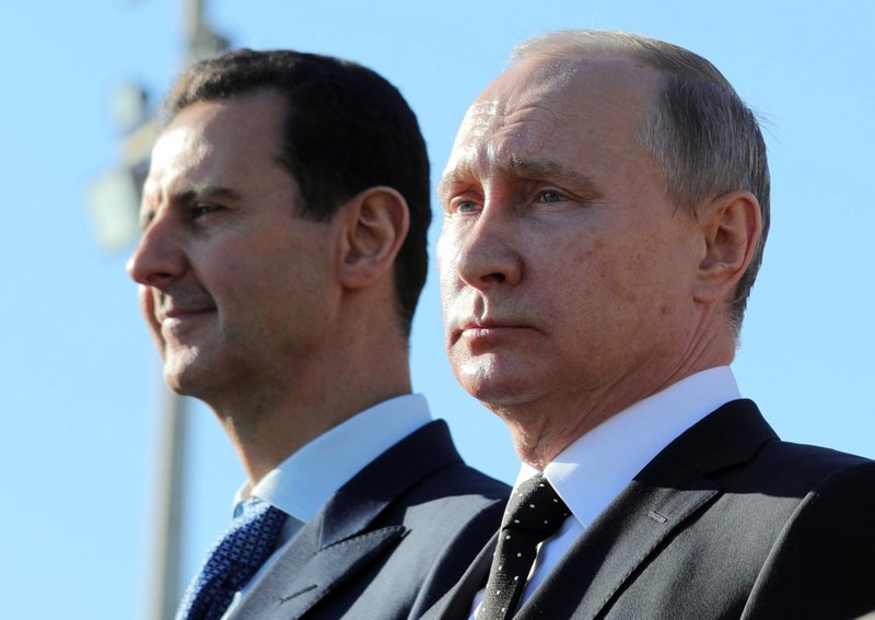 FILE - This Monday, Dec. 11, 2017 file photo, Russian President Vladimir Putin, right, and Syrian President Bashar Assad watch the troops marching at the Hemeimeem air base in Syria. Nearly seven years into the conflict, the war in Syria seems on one level to be winding down, largely because of Russian-backed government victories and local cease-fires aimed at freezing the lines of conflict. (Mikhail Klimentyev, Sputnik, Kremlin Pool Photo via AP, File)