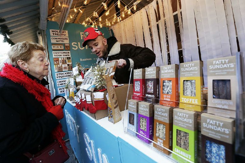 Anthony Cherrie of Fatty Sundays chats with a customer at a holiday market in New York City recently. Small retailers like Fatty Sundays say Christmas sales were up this year. 
