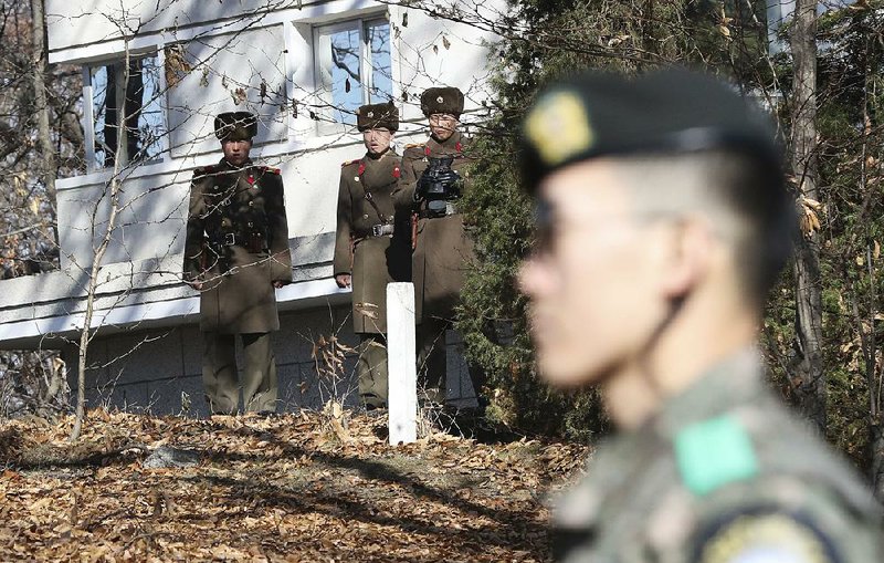 North Korean soldiers in late November guard the spot where one of their peers fled to South Korea earlier this year. Testing for radiation poisoning of four defectors so far has been inconclusive. 