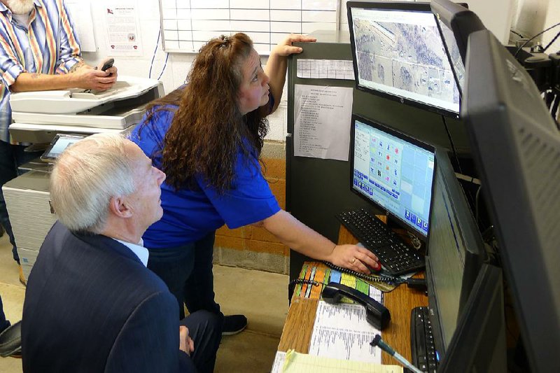 Madison County sheriff’s office Sgt. Lola Mitchell on Wednesday in Huntsville shows Gov. Asa Hutchinson how the digital mapping program will help with law enforcement and emergency calls. 