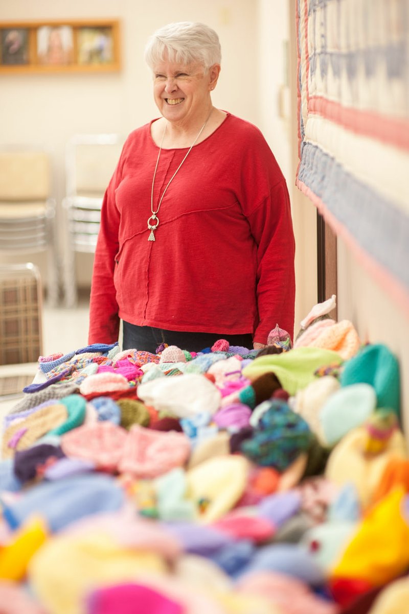 NWA Democrat-Gazette/LARA JO HIGHTOWER Betty Johnson of Springdale stands behind the 300 kitted and crocheted hats she made to be worn by babies and children at the new Arkansas Children's Northwest children's hospital in Springdale. The project took her just about a year.