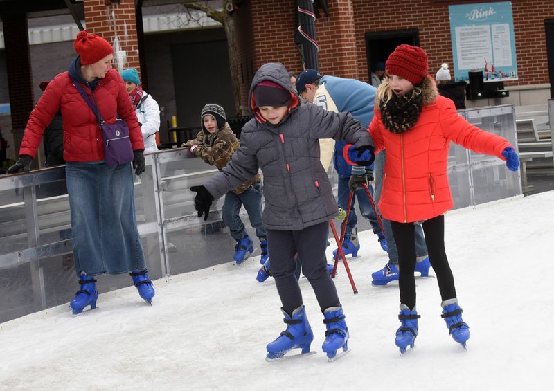 NWA Democrat-Gazette/FLIP PUTTHOFF Skaters circle the ice Wednesday at The Rink at Lawrence Plaza. Chilly weather drew crowds of skaters to the rink.