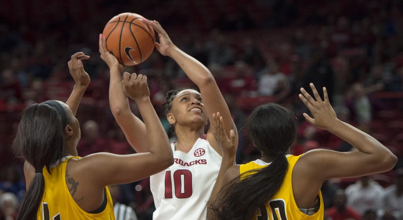 Razorbacks forward/center Kiara Williams (10) reaches for a shot as Grambling State Lady Tigers guard Monisha Neal (4) and forward Alexus Williams (30) cover her during a basketball game on Thursday, December 28, 2017 at Walton Arena in Fayetteville