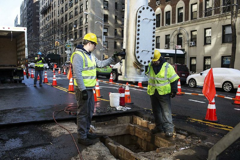 A ULC Robotics crewman guides a launch tube containing a cast-iron sealing robot over a natural-gas line in New York earlier this month. 
