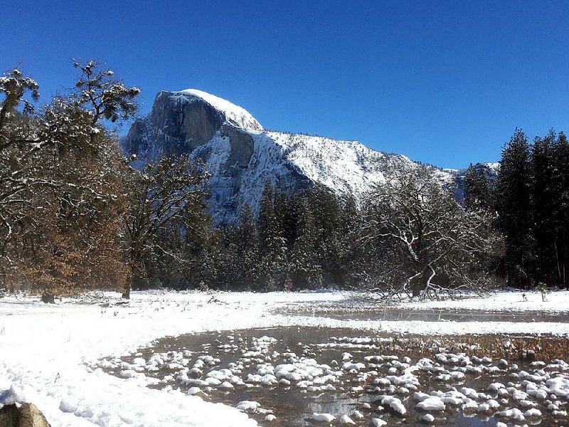 The famous Half Dome towers up over the snowy Yosemite National Park in the winter. The park is less crowded and offers different activities for winter visitors.
