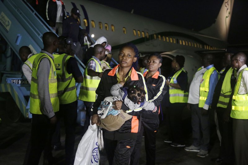 FILE - In this Dec. 5, 2017, file photo, Nigerian returnees from Libya disembark from a plane upon arrival at the Murtala Muhammed International Airport in Lagos, Nigeria. An emergency effort has begun to repatriate thousands of migrants stranded in camps across Libya, but now the returnees are posing a challenge. Back home in countries across Africa, they face the same conditions that led them to leave: high unemployment, often weak economies, an increasingly harsh climate. Governments are under pressure to give their citizens a reason to stay. (AP Photo/Sunday Alamba, File)