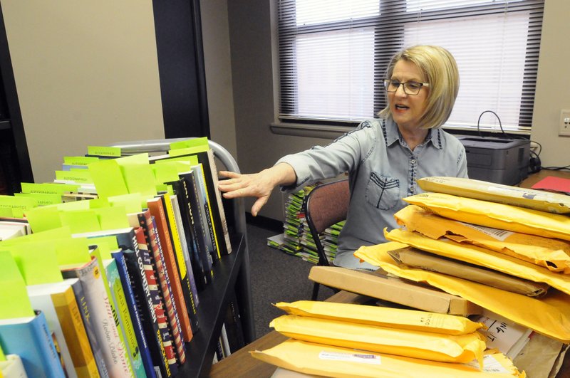 Cherie Geiser, a volunteer with the Benton County Literacy Council, sorts through donated books before the
2017 Scrabble Wars. The 2018 Scrabble Wars benefit will be Jan. 27 at Four Points by Sheraton in Bentonville.