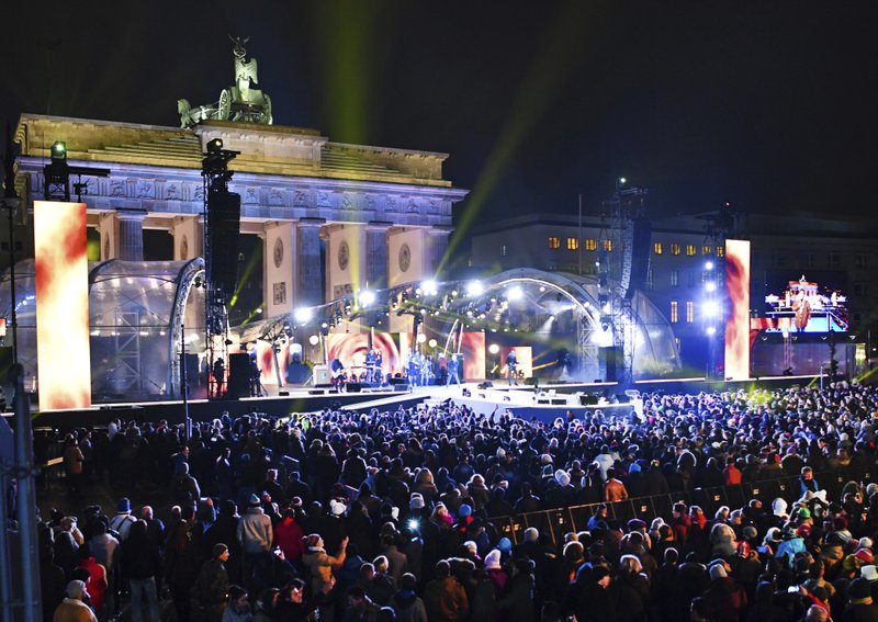 FILE - In this Dec. 31, 2016 file photo numerous visitors stand in front of the stage at the Brandenburg Gate where the New Year's Eve party is taking place in Berlin, Germany. The head of a German police union DpolG Rainer Wendt is criticizing Saturday, Dec. 31, 2017, the creation of a special safe zone for women at the annual New Year's Eve party in front of Berlin's iconic Brandenburg Gate. (Jens Kalaene/dpa via AP, file)