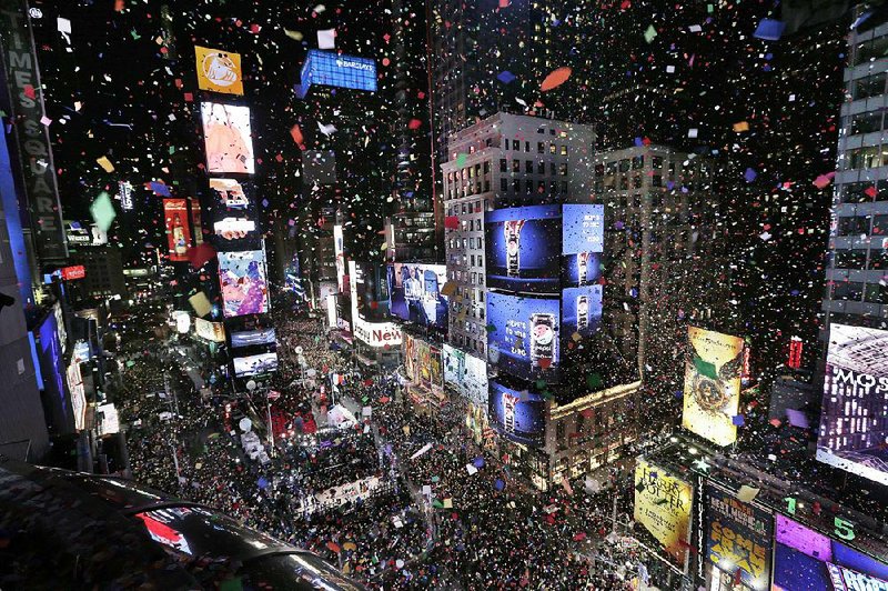 Confetti drops over the crowd as the clock strikes midnight during the New Year’s celebration at Times Square in New York City. 