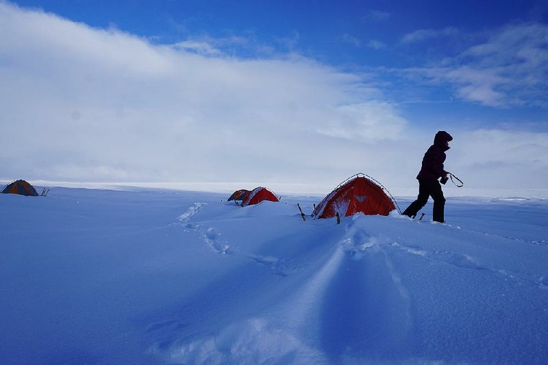 A researcher walks on the snowy landscape of the Greenland ice sheet as part of work done this summer by a team that included University of Arkansas, Fayetteville scientists. The researchers camped in the remote area to gather data. 
