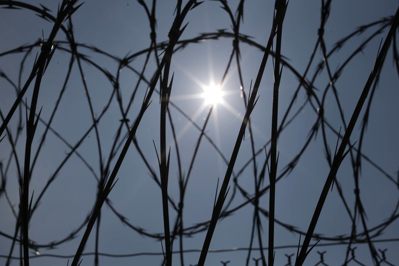 FILE - In this Saturday, April 26, 2014 file photo, the sun shines through concertina wire on a fence at the Louisiana State Penitentiary in Angola, La. Nearly two years after the January 2016 U.S. Supreme Court ruling that prison inmates who killed as teenagers are capable of change and may deserve eventual freedom, the question remains unresolved: Which ones should get a second chance? (AP Photo/Gerald Herbert)