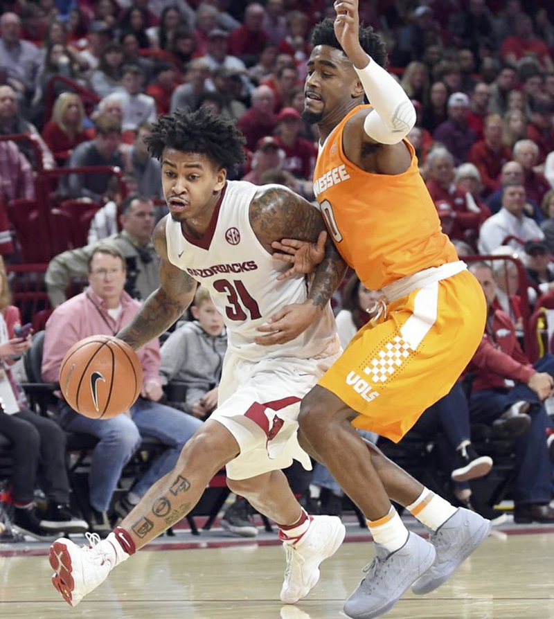 Craven Whitlow/Special to The Sentinel-Record SURVIVAL: Arkansas senior guard Anton Beard (31) works past the defense of Tennessee sophomore guard Jordan Bone (0) during Saturday's 95-93 overtime win for the Hogs at Bud Walton Arena in Fayetteville. The Razorbacks have their second SEC game of the season tonight on the road at Mississippi State.