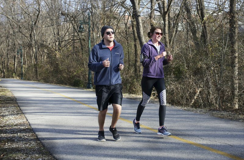 NWA Democrat-Gazette/DAVID GOTTSCHALK Brian and Megan Anderson, of Plano, Texas, jog Dec. 26 on the Razorback Greenway that runs through the Fay Jones Parkland located west of West Avenue near the Fayetteville Public Library. The city of Fayetteville will get nearly $1.8 million, from the Walton Family Foundation's Design Excellence Program, to design a series of open spaces within an interactive cultural arts corridor downtown. Once complete, the corridor will provide better access to arts and entertainment destinations such as the Walton Arts Center, TheatreSquare's future building, Community Creative Center and the library.