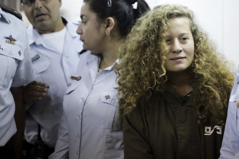 File - In this Thursday, Dec. 28, 2017 file photo, Ahed Tamimi is brought to a courtroom inside Ofer military prison near Jerusalem. Tamimi, 16, from the village of Nebi Saleh on Monday for attacking the soldiers as well as for previous altercations. It extended her remand for 8 days. (AP Photo/Mahmoud Illean, File)