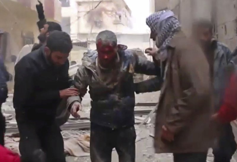 In this frame grab from video released Monday Jan. 1, 2018 by the Syrian Civil Defense group, known as the White Helmets, Syrians help an injured man on a stretcher after an airstrike hit the Damascus suburb of Masraba, Syria. Opposition activists are reporting heavy clashes between government forces and insurgents east of Damascus, and at least a dozen airstrikes. (Syrian Civil Defense, via AP)