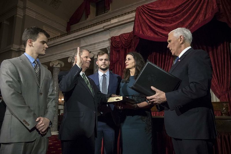 Vice President Mike Pence (right) administers the Senate oath of office during a mock swearing-in ceremony Wednesday for Sen. Doug Jones, D-Ala. Jones was joined by his wife, Louise, and their two sons. 