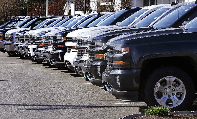 Chevrolet Silverados sit on display at a dealership in Manchester, N.H., in April. Auto sales in December ended the year on a bright note, but analysts think sales will fall a bit further this year. 