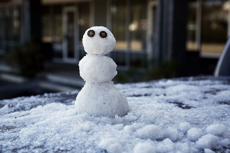 A snowman built by Marty Ritter sits on the back of his truck in Tallahassee, Fla., after a rare snowfall. 