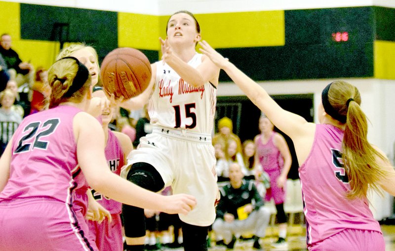 RICK PECK/SPECIAL TO MCDONALD COUNTY PRESS McDonald County's Ragan Wilson goes in for a layup as Neosho's Caitlyn Johnson (22) and Mary Dunbar (5) look on during the Lady Mustangs' 54-30 loss on Dec. 28 in the opening round of the 63rd Neosho Holiday Classic.