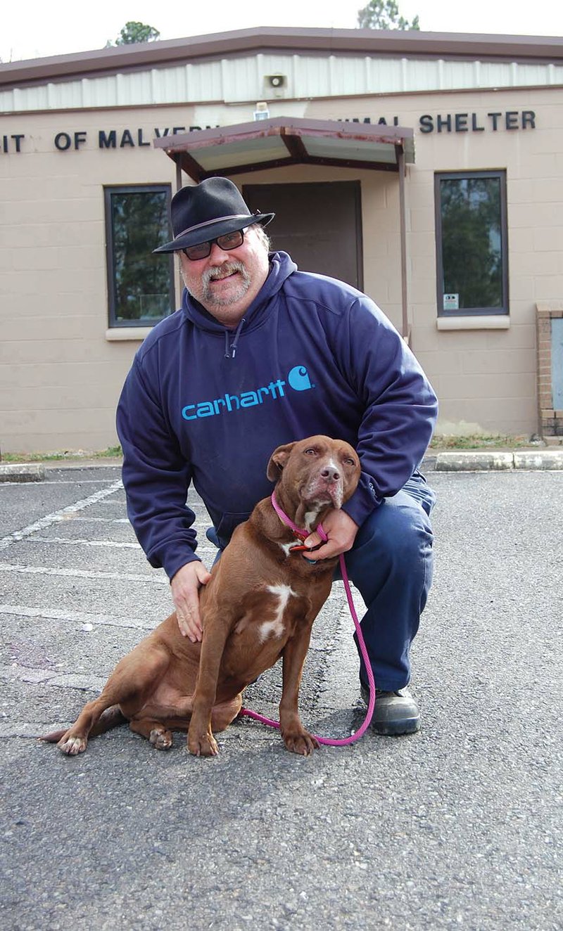 Scott Efird, director of the Malvern Animal Shelter, holds Doogie, a pit bull he rescued. Efird has also been the pastor at The Church of Faith in Malvern for the past six years. He said the birth of his daughter, Kazz Efird, is what inspired him to turn his life around after spending his youth partying. 