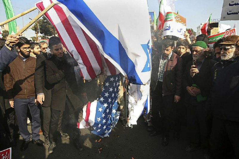 Iranians burn U.S. and Israeli flags at a pro-government demonstration Thursday in the city of Mashad.