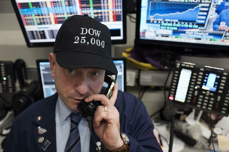 Vincent Pepe, a commodities broker with ICAP Corp., wears a commemorative hat while working at the New York Stock Exchange on the Dow’s record-setting day. 