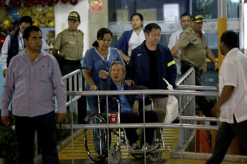 Former Peruvian President Alberto Fujimori is wheeled out of a clinic Thursday in Lima, days after his pardon. 