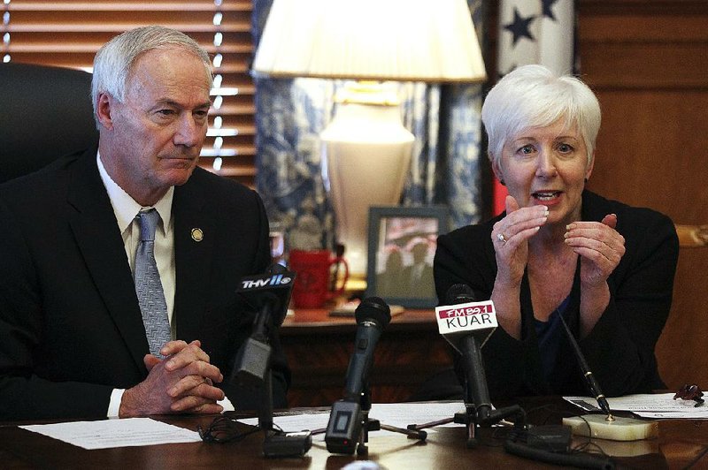 Gov. Asa Hutchinson and state Department of Human Services Director Cindy Gillespie discuss shrinking Medicaid rolls and costs at a news conference Thursday at the state Capitol.