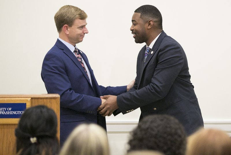 In this Sept. 21, 2017 photo, Republican Bob Thomas, left, and Democrat Joshua Cole, candidates for the 28th District seat in the Virginia House of Delegates, shake hands following their debate at the University of Mary Washington in Fredericksburg, Va. A federal judge is set to hear arguments Friday, Jan. 5, 2018, in a federal lawsuit challenging the results of a House race after numerous voters were assigned to the wrong district and thus given the wrong ballots. Democrat Joshua Cole lost the Fredericksburg-area seat to Republican Bob Thomas by 73 votes in a race that went to a recount. (Mike Morones/The Free Lance-Star)