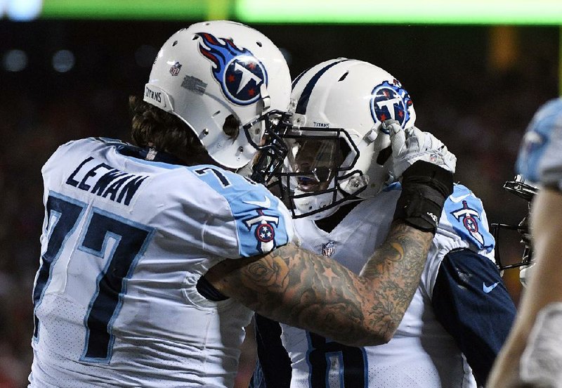 Tennessee Titans quarterback Marcus Mariota (right) is congratulated by tackle Taylor Lewan after Mariota’s touchdown reception on his own pass during the Titans’ NFL playoff victory against the Kansas City Chiefs on Saturday in Kansas City.