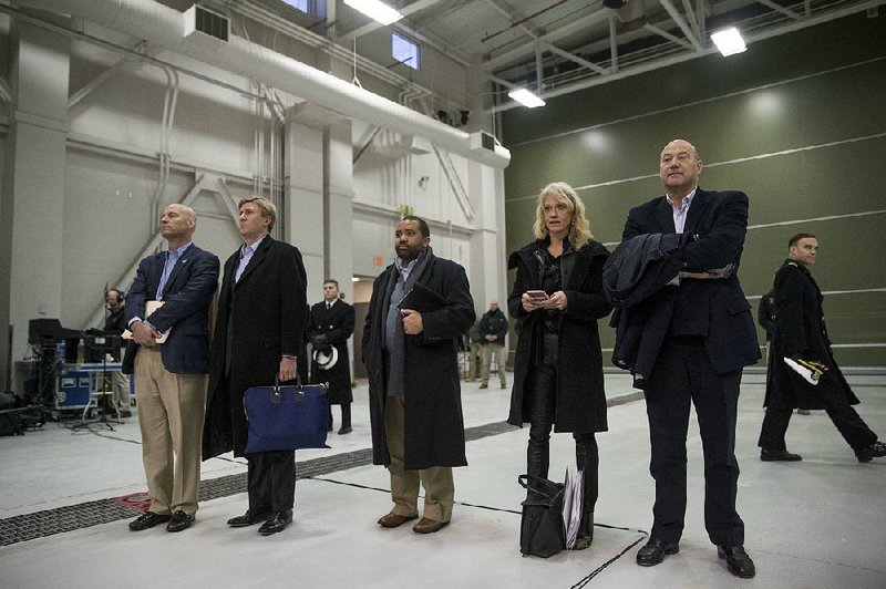 White House staff members Marc Short (left), Nick Ayers (second from left), Kellyanne Conway and Gary Cohn (right) stand by Saturday as President Donald Trump speaks at a news conference after a retreat at Camp David in Maryland. The man at center is not identified. 