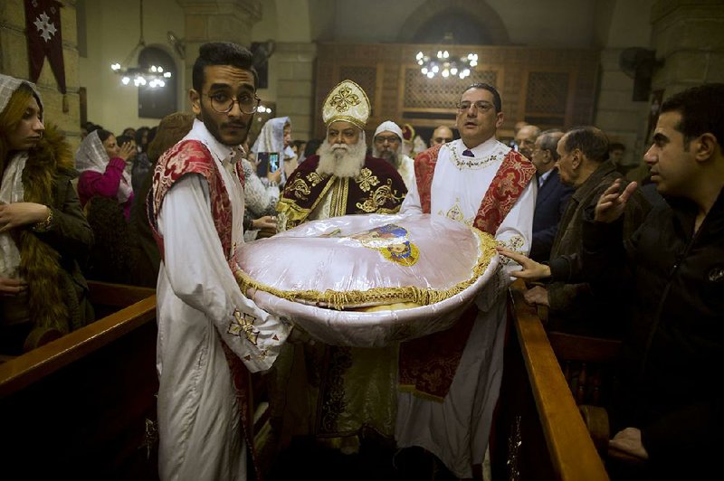 Communion bread is carried Saturday at the Virgin Mary church in Cairo on the eve of the Coptic Christians’ Christmas. 