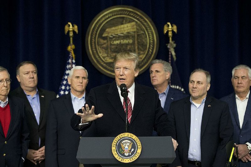President Donald Trump, at a news conference Saturday at Camp David in Maryland with Vice President Mike Pence (second from left), lawmakers and other officials, said that Mexico will pay for a border wall “in some form.” 