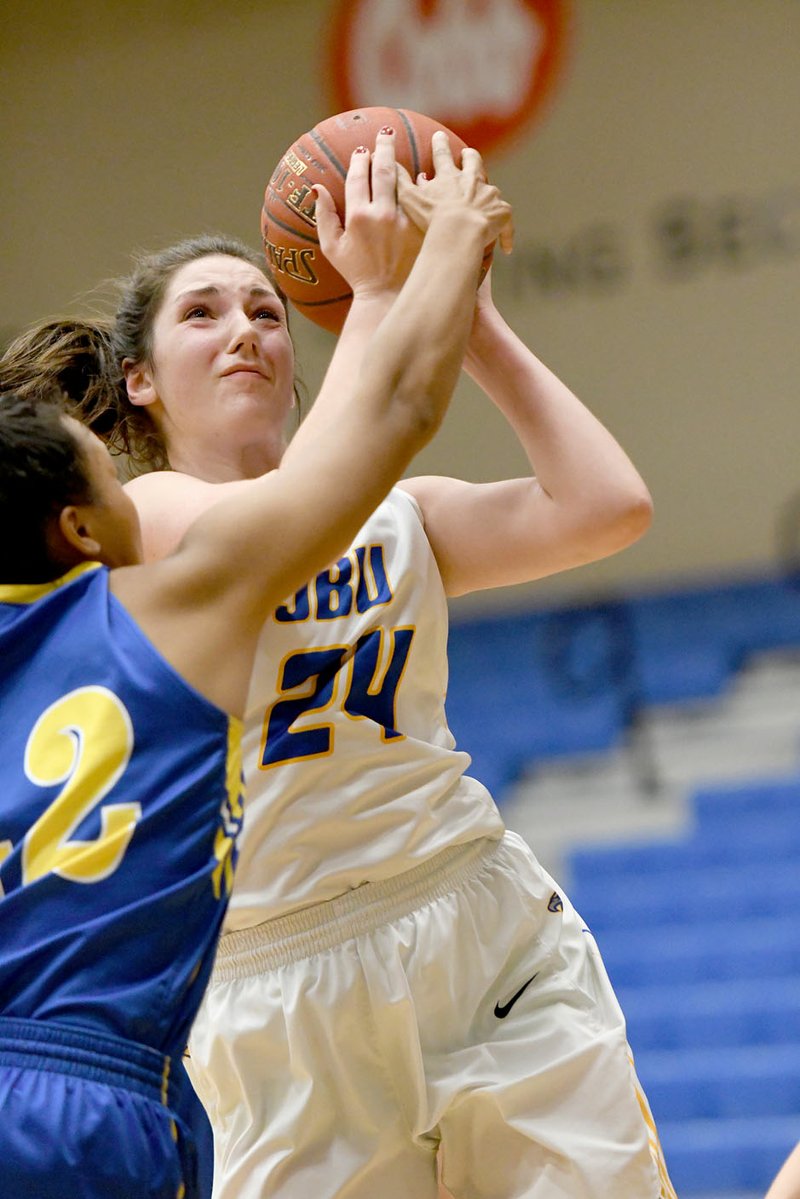 Bud Sullins/Special to Siloam Sunday John Brown junior forward Baily Cameron shoots over Wayland Baptist's Jada Riley during the second half of Thursday's game at Bill George Arena. Cameron scored 19 points as the Golden Eagles defeated the Flying Queens 72-64.