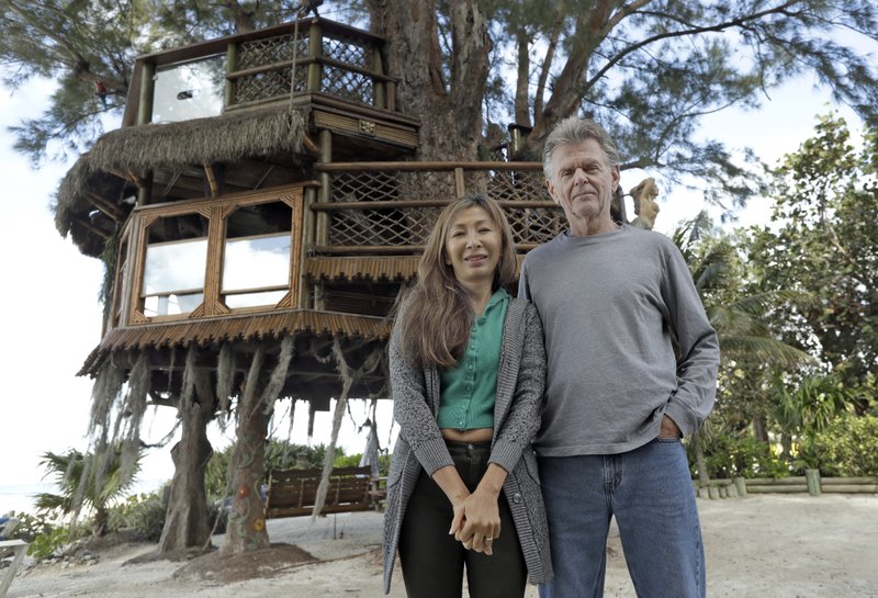 The Associated Press TREEHOUSE HUGGERS: Lynn Tran and her husband Richard Hazen pose near their Australian pine treehouse Thursday in Holmes Beach, Fla. The couple is hoping the U.S. Supreme Court will hear their case after city and state officials ordered the treehouse removed.