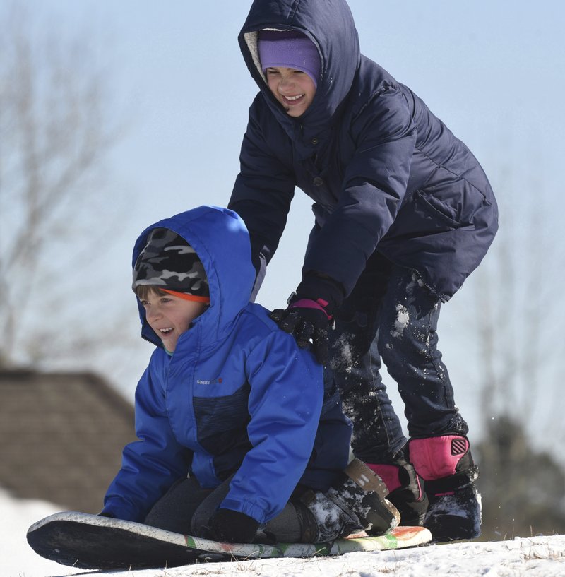 The Associated Press SMALL HILL SLEDDING: Cylie Echols pushes Matt Caracciolo down a small hill as they enjoy another day of sledding Friday in Leland, N.C.